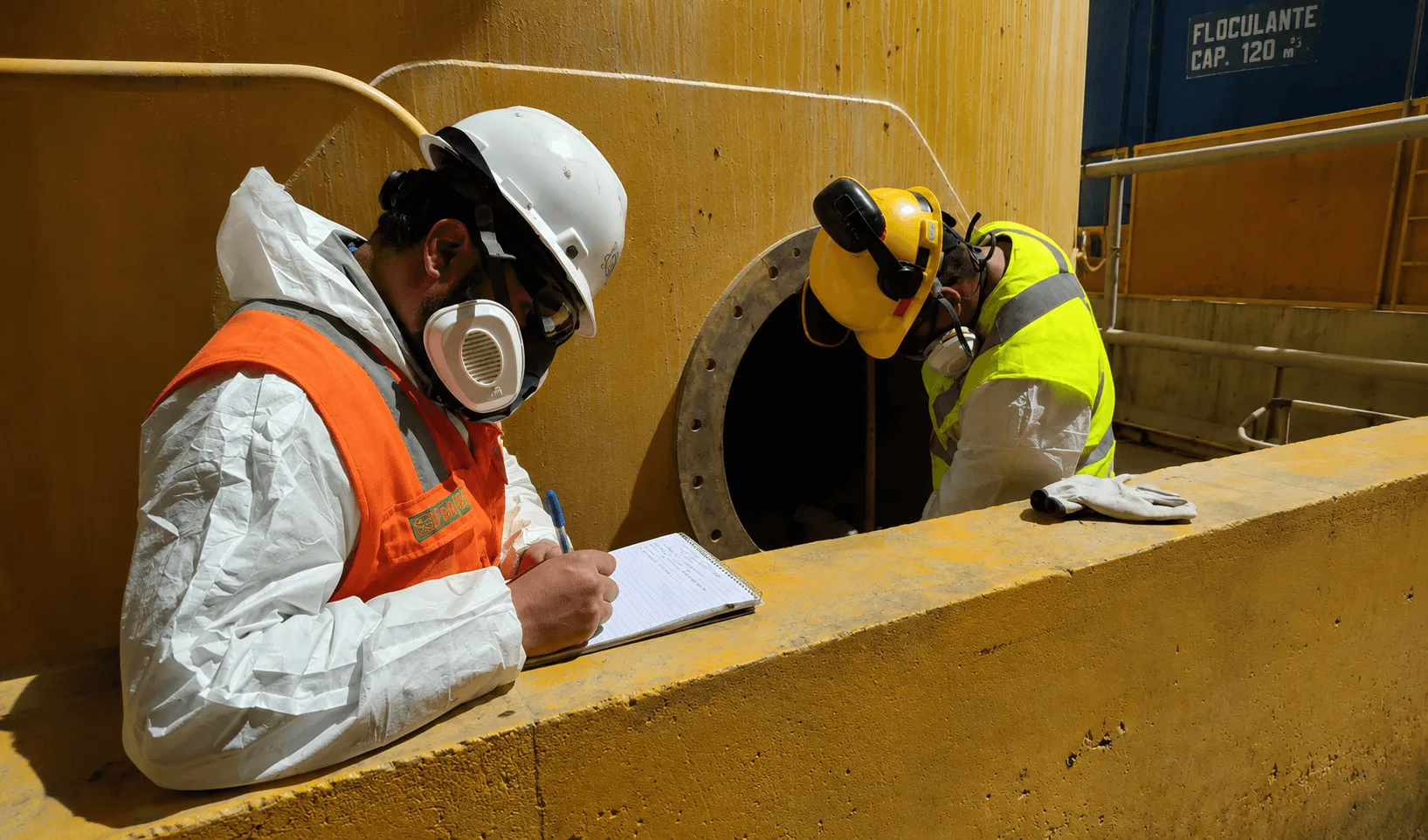 Técnicos especializados realizando labores de supervisión e inspección en una operación de mantenimiento industrial con equipos de protección personal.